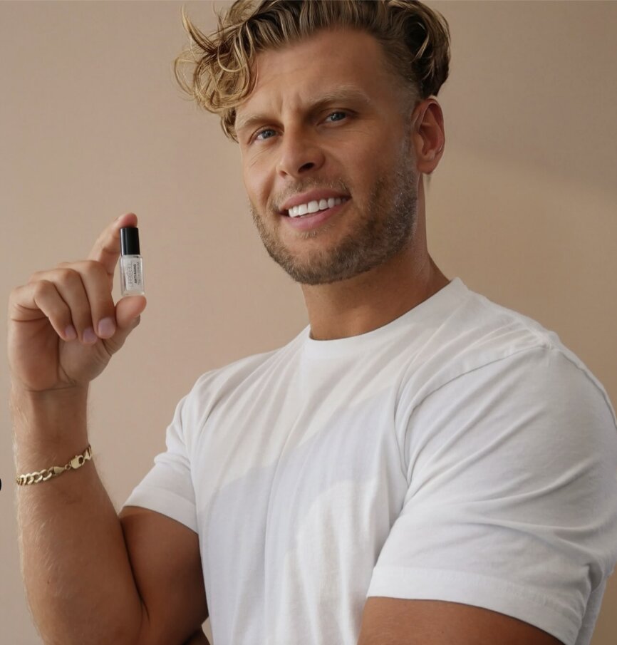 Kyle smiling and holding a small bottle of LifeCell Anti-Aging Teeth Serum