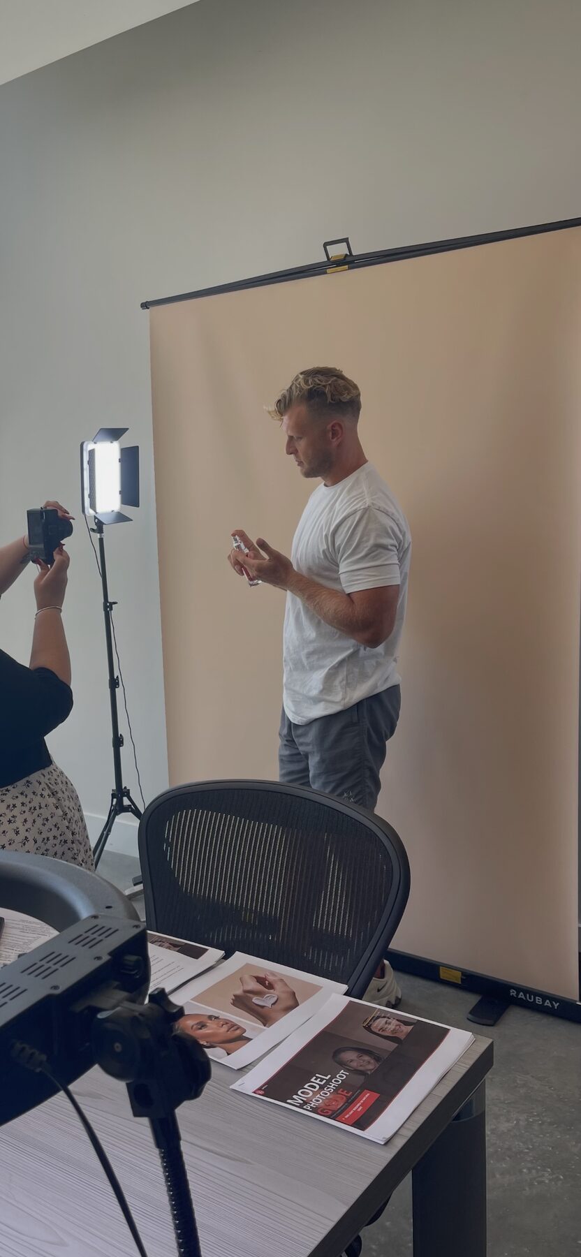 Kyle on set at a product photo shoot, holding a bottle under studio lights